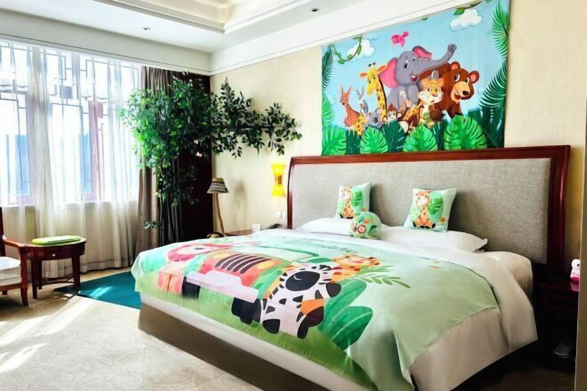 A hotel room with a large bed, a desk, and a window with curtains.