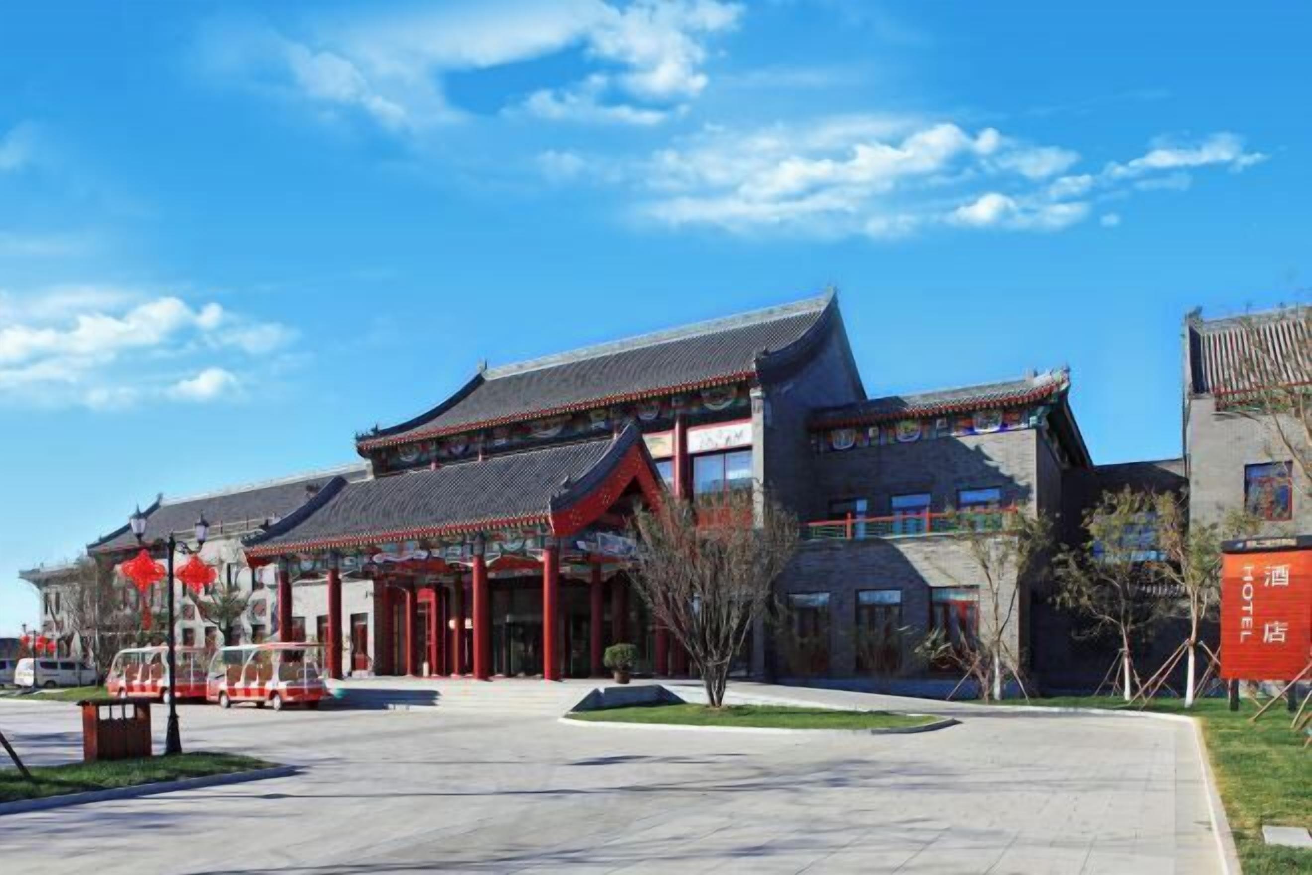 A traditional building with a tiled roof, a courtyard, and a sign indicating a hotel.