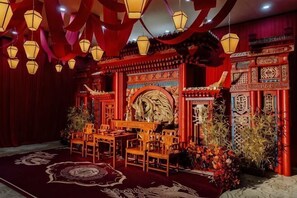 A traditional Chinese room with red decor, a patterned carpet, and a central table with chairs. - Tianjin Binhai One Hotel (HUANGGANG COMMUNITY BINHAI NEW)