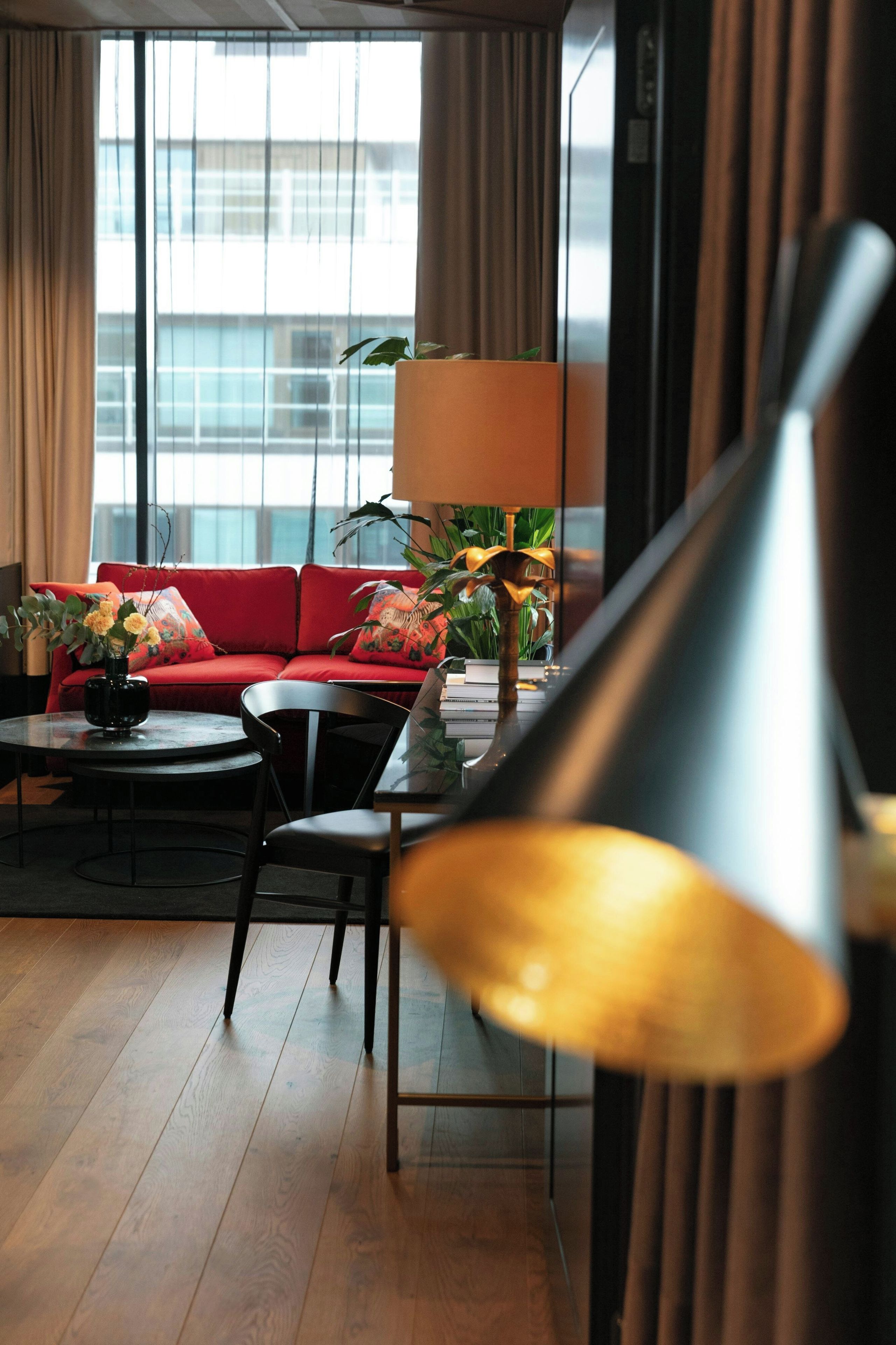 Un salon moderne avec un canapé rouge, une table basse ronde et un lampadaire.