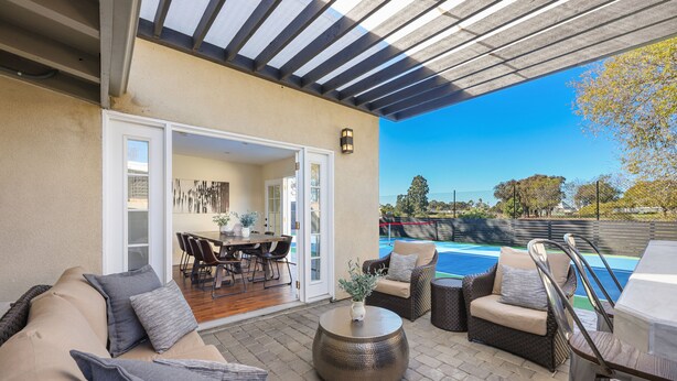 Un espace extérieur aménagé avec une terrasse, une piscine, des sièges et une partie abritée.
