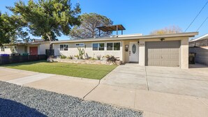 Une maison à deux étages avec un garage, un patio couvert et une pelouse bien entretenue.