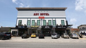 Edificio de ADY HOTEL con varias fachadas, incluyendo una tienda de vapeadores y una barbería.