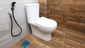Un baño moderno con inodoro, ducha y un desagüe azul.