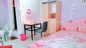 Une chambre à coucher comprenant un lit, un bureau, une chaise, une armoire et un ventilateur.
