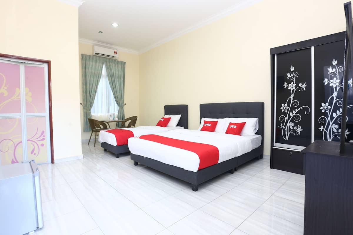 Habitación de hotel con dos camas, un escritorio y una silla.