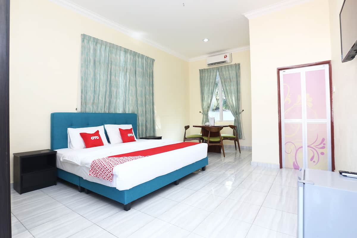 Una habitación de hotel con una cama, un escritorio y una silla.