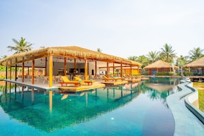 A pool area with lounge chairs and thatched-roof structures. - Floating Khmer Village Resort (Siem Reap)