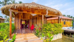 A wooden structure with a thatched roof, a wooden deck, and a water feature. - Floating Khmer Village Resort (Siem Reap)