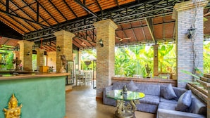 A spacious lobby with a green reception desk, a glass coffee table, and a grey sofa. - Floating Khmer Village Resort (Siem Reap)