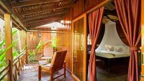 A wooden room with a bed, a chair, and a table. - Floating Khmer Village Resort (Siem Reap)