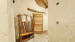 A rustic bathroom with wooden shelves and a wooden door. - Ella Retreat Hotel (Ella)