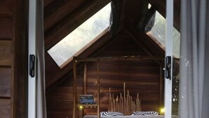 A cozy attic bedroom with a bunk bed, wooden beams, and a skylight. - Ella Retreat Hotel (Ella)