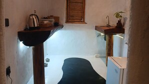 A small, narrow room with a wooden shelf, a window with shutters, a sink, and a small white cabinet. - Ella Retreat Hotel (Ella)