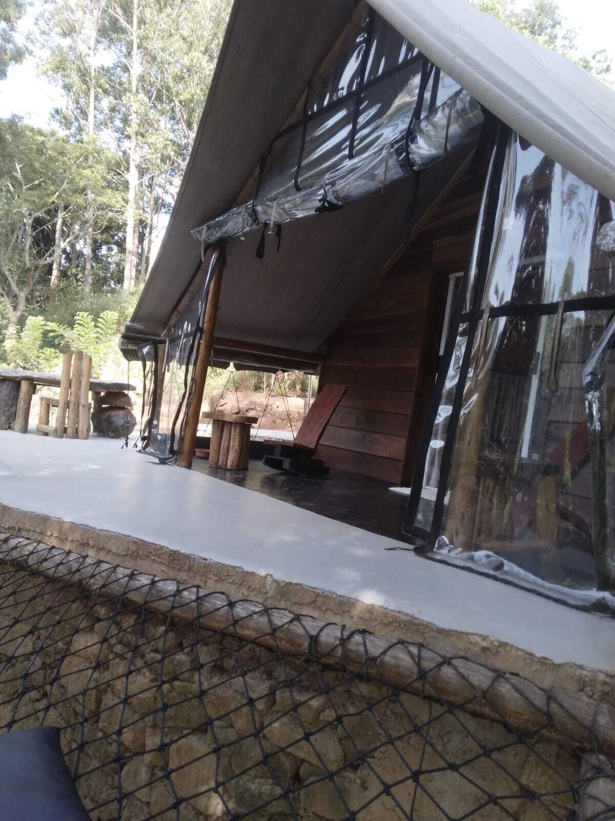 Une cabane rustique avec un toit en pente, des murs en bois et un petit espace porche.