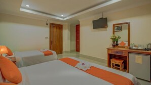 A hotel room with two beds, a desk with a mirror, a television, and a small refrigerator. - Deluxe Double Room - Free breakfast (Kok chock commune)