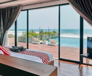 A bedroom with a large window overlooking a pool and ocean view. - Brand new absolute beachfront retreat (east selemadeg)