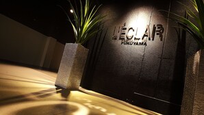 A dark wall with the text "LECLAR FUKUYAMA" illuminated by a light source. - Hotel L’eclair - Adults Only (Fukuyama)
