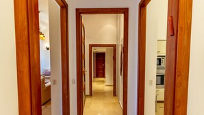 A hallway with wooden doors leading to a living area and a kitchen. - Art apartment in Mamila (Jerusalem)