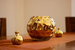A table with a decorative glass bowl and two smaller glass vases. - Art apartment in Mamila (Jerusalem)