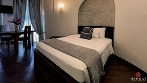 A hotel room with a bed, a desk, and a chair. - Haggai - Tourist Bangalow (Colombo)