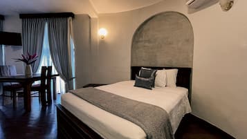 Une chambre d’hôtel avec un lit, un bureau et une chaise.