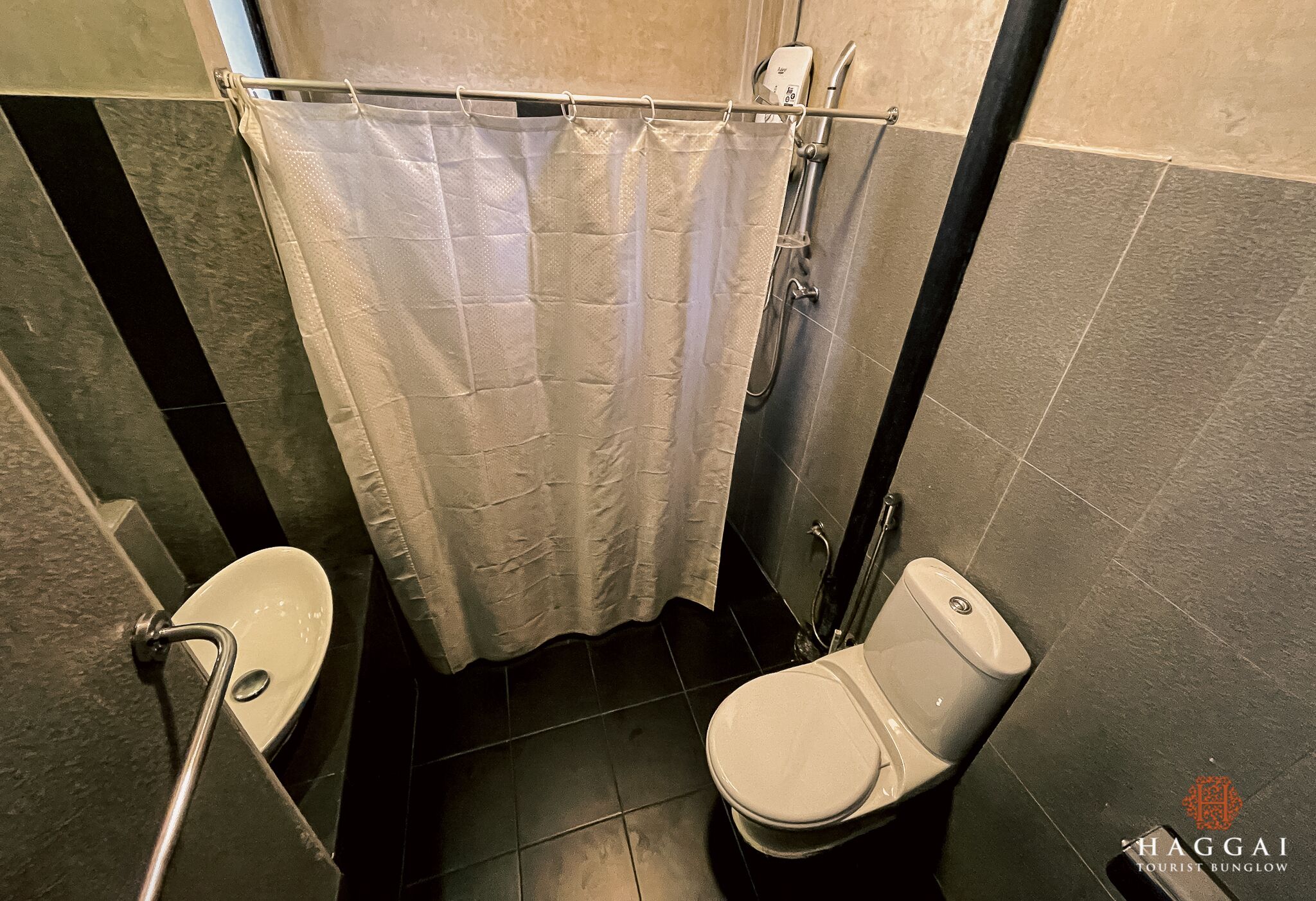 Kylpyhuone, jossa on suihkuverho, wc ja bidee.