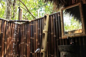 A bamboo fence with a water spout and a mirror. - NIKKI Peucang Resort (Peucang Island)