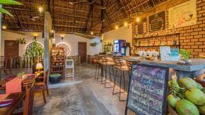 A restaurant with a rustic interior, featuring exposed brick walls, wooden furniture, and a chalkboard menu. - Deluxe Double Room - breakfast (Kok chock commune)