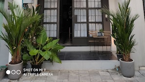 A building with a balcony, large windows, and potted plants. - 87 Oldtown @ River Pier (Bangkok)
