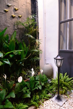 A garden area with various plants, a spherical decorative object, and a black lamp post.