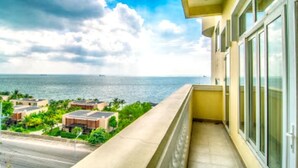 Ein Balkon mit Blick auf das Meer und Gebäude.