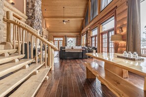 A wooden interior with a staircase, a fireplace, and a dining area. - Spirit Lodge at Silverstar (Vernon)
