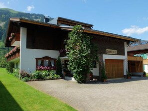 Un bâtiment à deux étages avec une façade en bois, une enseigne indiquant « ZIMMER » et une allée pavée.