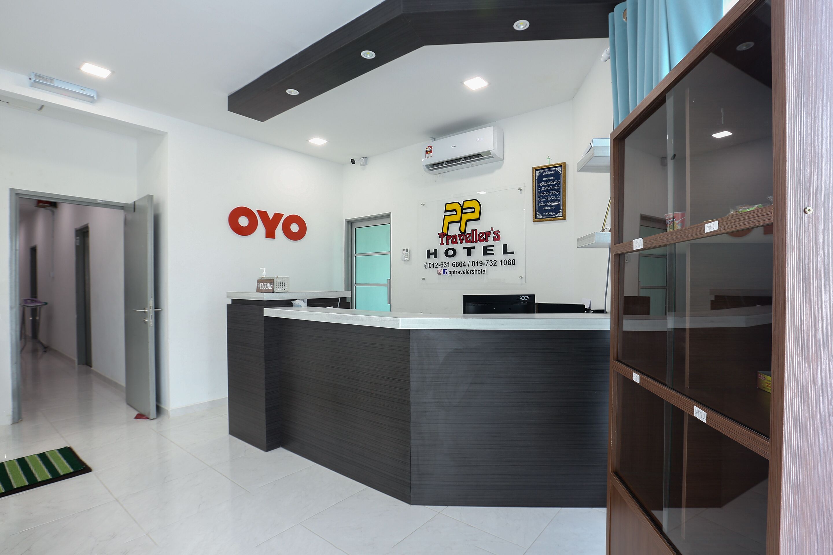 A hotel reception area with a modern design, including a reception desk, a wall-mounted air conditioner, and a visible door leading to other areas.