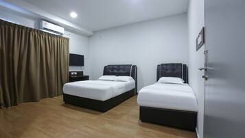 A hotel room with two beds, a flat-screen TV, an air conditioning unit, and a wooden floor.