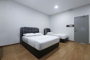 Una habitación de hotel con una cama grande, otra más pequeña y un armario.