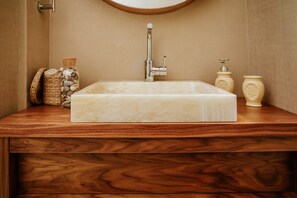 A rectangular bathroom sink with a wooden countertop, a mirror above it, and two soap dispensers on the right. - Luxury Triplex In Jerusalem Center (Jerusalem)