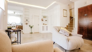A modern living room with a sofa, a coffee table, and a bookshelf. - Luxury Triplex In Jerusalem Center (Jerusalem)