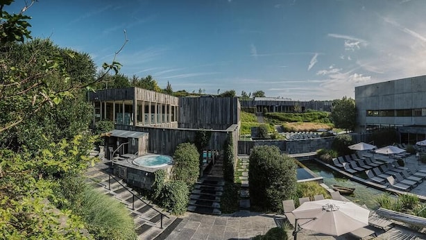 Et moderne resort med pool, udendørs siddepladser og en trappe til en træterrasse.