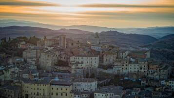 Une ville chargée d’histoire, avec une architecture dense, une tour imposante et, en toile de fond, des collines ondoyantes.