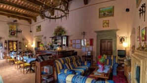 A spacious room with a dining area, a fireplace, and a television.