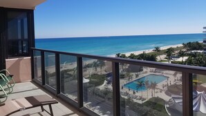 A balcony with a clear view of the beach and ocean.