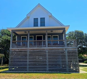 A two-story building with a balcony on the upper floor. - Nags Head OCEANSIDE! 3 Bedroom 4 Bath Home! Beautiful 5 Star Property! (Nags Head)