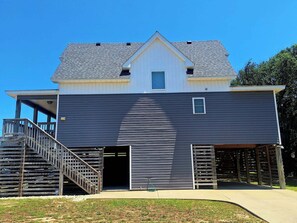 Une maison à deux étages avec un porche couvert, un escalier et un garage.