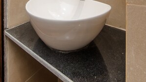 A bathroom with a white sink, a mirror, and a towel hanging on the wall. - Hotel Axis International (Mumbai)