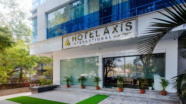 A modern hotel entrance with a sign reading "HOTEL AXIS INTERNATIONAL". - Hotel Axis International (Mumbai)
