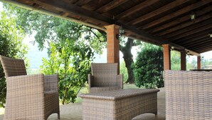 Un patio coperto con mobili in vimini e un pilastro in mattoni.