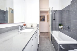Un bagno moderno con una grande vasca da bagno, una cabina doccia separata e un mobile lavabo.