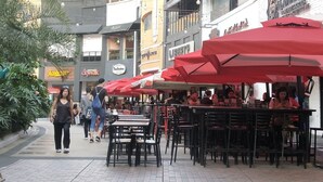 Un café en plein air avec des parasols rouges, des tables et des chaises.